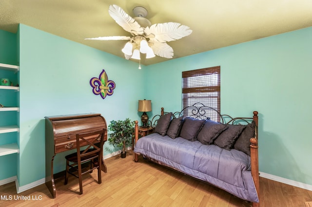 bedroom with light wood finished floors, baseboards, and a ceiling fan