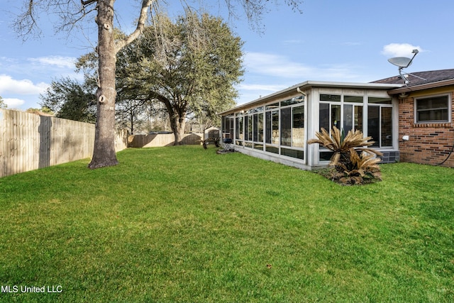 view of yard with a sunroom and a fenced backyard