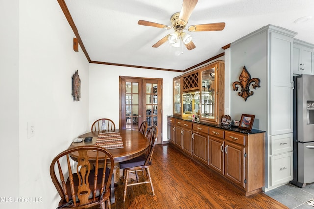 dining area featuring dark wood-type flooring, french doors, ornamental molding, and ceiling fan