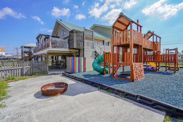 view of play area with a patio area, a fire pit, and a wooden deck