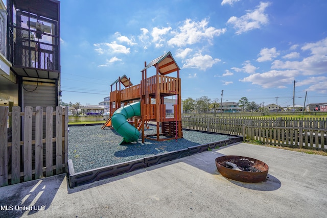 view of jungle gym with a patio and an outdoor fire pit