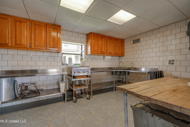 kitchen featuring a paneled ceiling and wooden counters