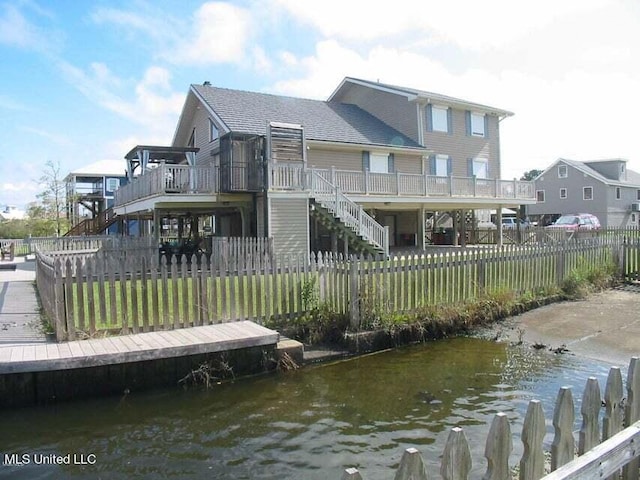 rear view of house with a deck with water view