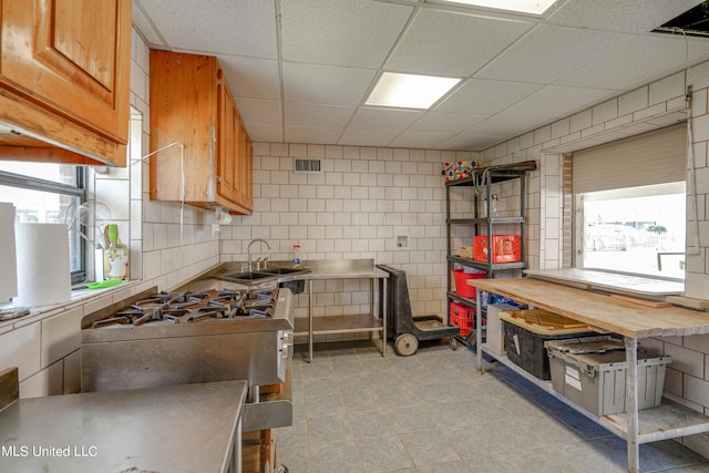 kitchen featuring a drop ceiling, sink, and a wealth of natural light