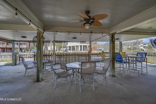 view of patio with a water view and ceiling fan