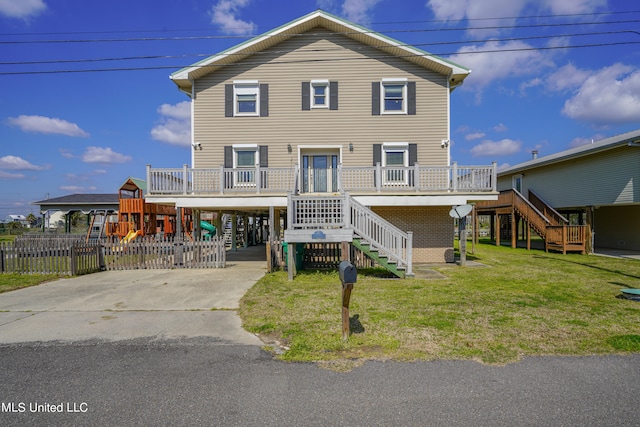 view of front of house featuring a wooden deck, a carport, and a front yard