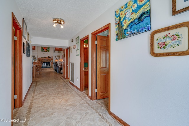 hallway with light tile patterned flooring and a textured ceiling