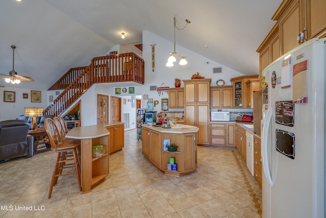 kitchen with a center island, decorative light fixtures, high vaulted ceiling, and white appliances