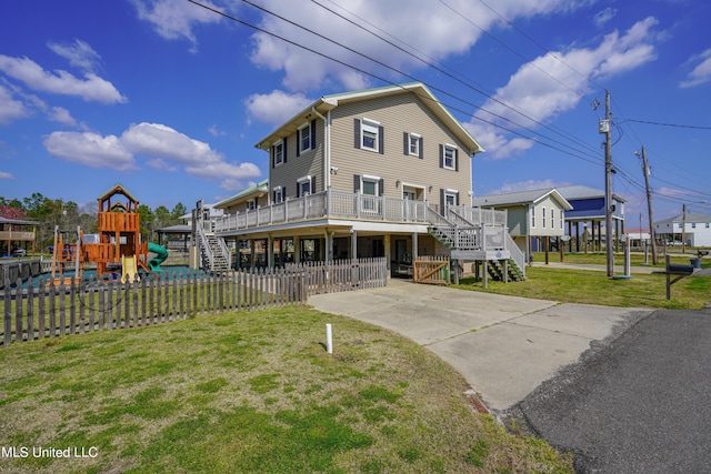 view of front of home with a front lawn, a deck, and a playground