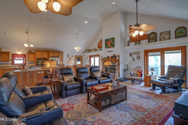 tiled living room with ceiling fan, high vaulted ceiling, a textured ceiling, and a stone fireplace