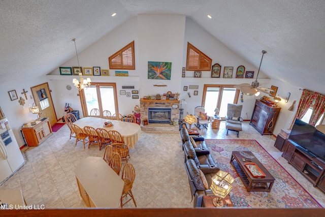 living room featuring high vaulted ceiling, a textured ceiling, and ceiling fan with notable chandelier