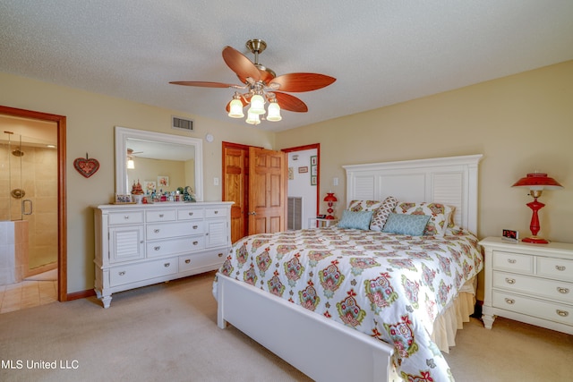 carpeted bedroom with ceiling fan and a textured ceiling