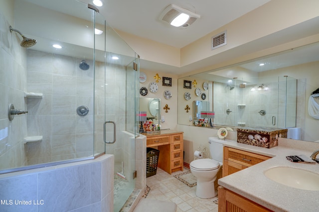 bathroom featuring a shower with door, vanity, toilet, and tile patterned flooring