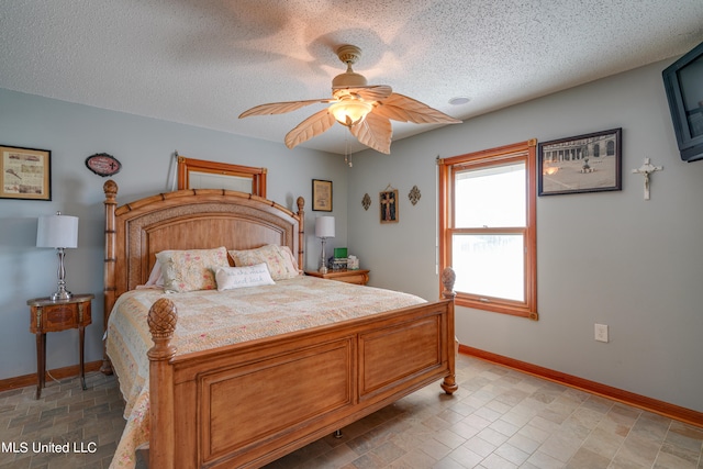 bedroom with a textured ceiling and ceiling fan