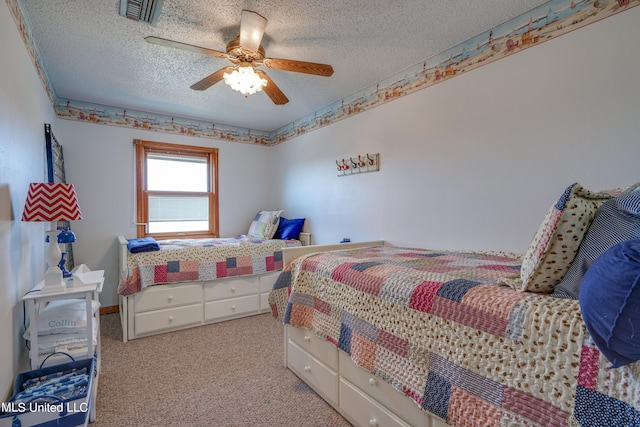 bedroom with a textured ceiling, light colored carpet, and ceiling fan