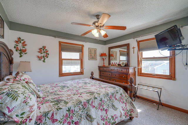 carpeted bedroom featuring ceiling fan and a textured ceiling