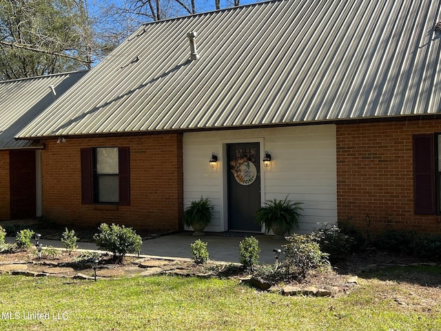 view of front of house with brick siding and metal roof