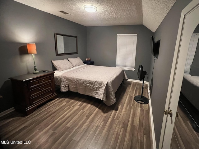 bedroom featuring visible vents, wood finished floors, and a textured ceiling