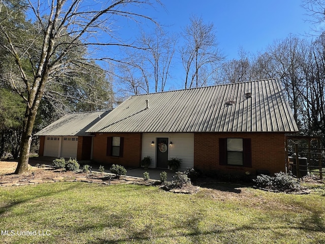 view of front facade featuring brick siding, an attached garage, metal roof, and a front lawn