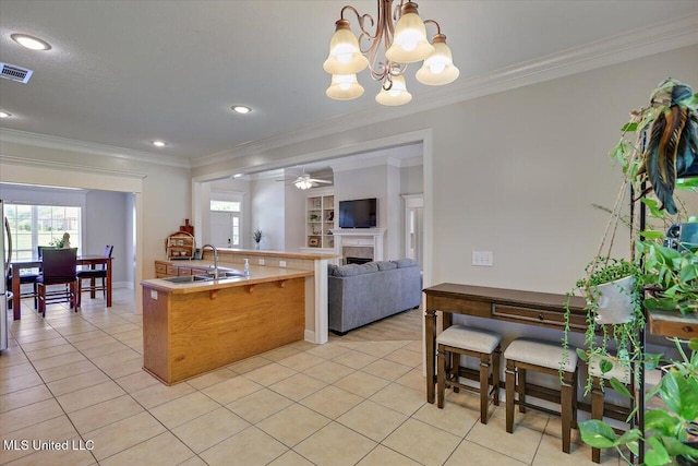 213 Pecan Cir, Brandon, MS 39042 - kitchen with a sink, crown molding, light tile patterned flooring, a fireplace, and open floor plan