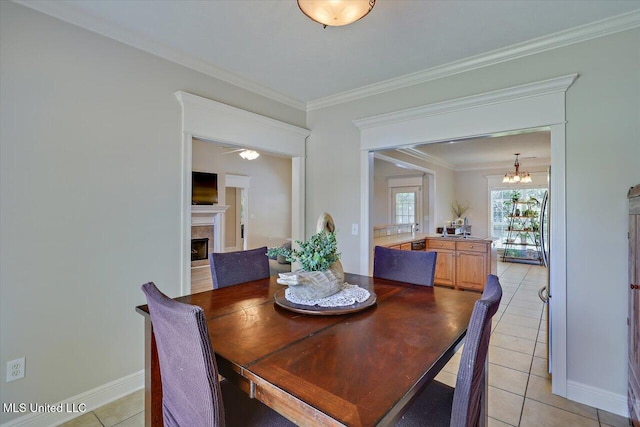 213 Pecan Cir, Brandon, MS 39042 - dining room featuring light tile patterned flooring, a tiled fireplace, a chandelier, crown molding, and baseboards