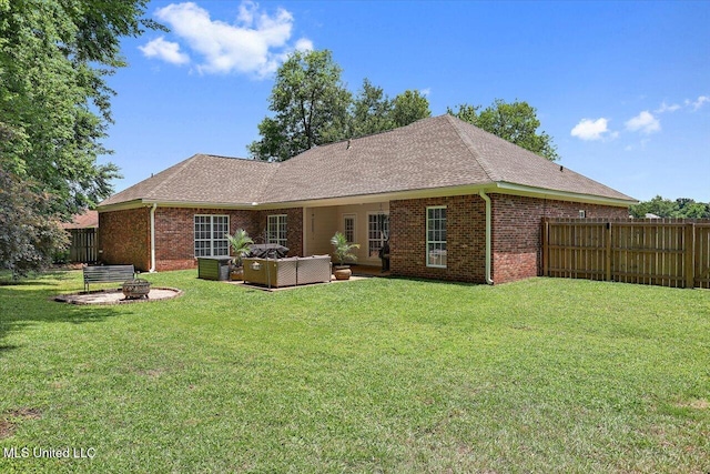 213 Pecan Cir, Brandon, MS 39042 - back of house featuring brick siding, an outdoor living space with a fire pit, a shingled roof, and a garage