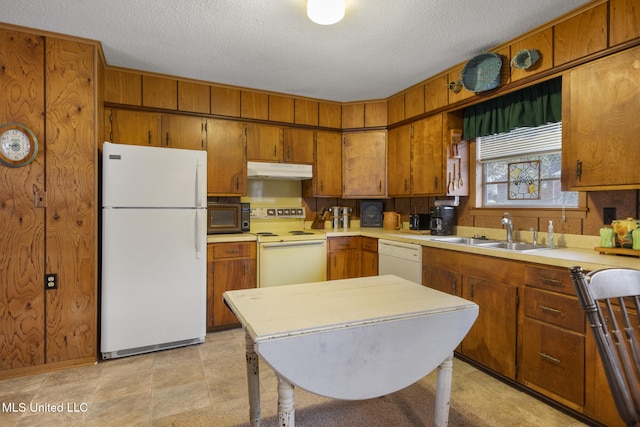 kitchen featuring white appliances, sink, and a textured ceiling