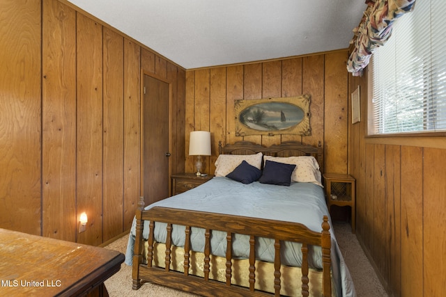 carpeted bedroom featuring wood walls