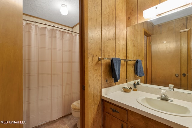 bathroom featuring toilet, wood walls, a textured ceiling, vanity, and tile patterned flooring