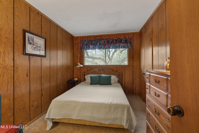 carpeted bedroom featuring wood walls