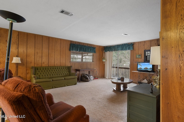 carpeted living room featuring wood walls