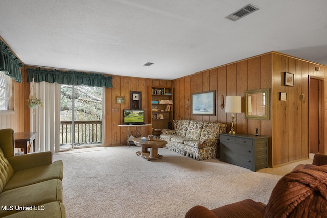 living room with light colored carpet and wooden walls