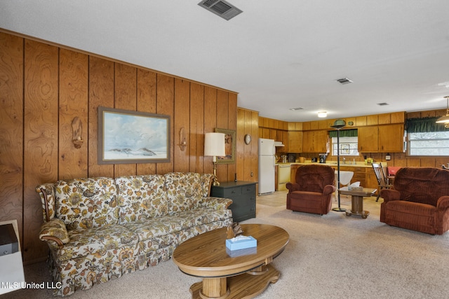 carpeted living room with wood walls