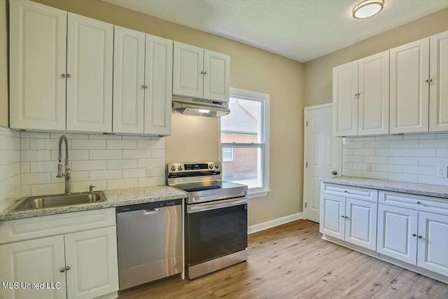 1204 Jackson St, Vicksburg, MS 39183 - kitchen featuring stainless steel appliances, a sink, under cabinet range hood, and white cabinets