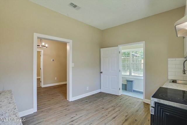 1204 Jackson St, Vicksburg, MS 39183 - interior space featuring light wood finished floors, an inviting chandelier, visible vents, and baseboards