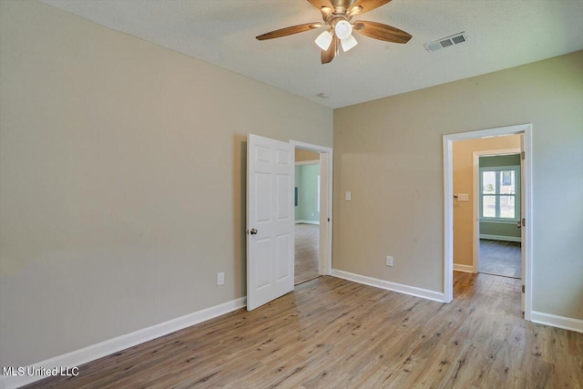 1204 Jackson St, Vicksburg, MS 39183 - empty room featuring light wood-style floors, visible vents, baseboards, and a ceiling fan