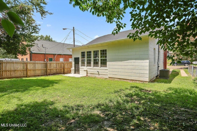 1204 Jackson St, Vicksburg, MS 39183 - rear view of property featuring a lawn, central AC unit, and fence