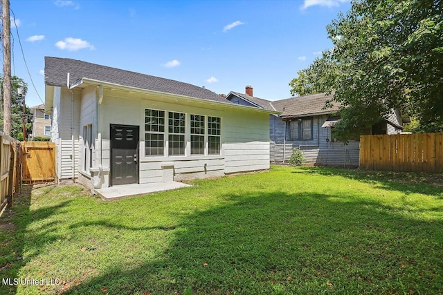 1204 Jackson St, Vicksburg, MS 39183 - back of property with a yard, roof with shingles, a chimney, and a fenced backyard