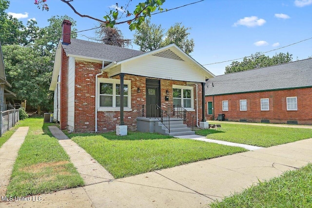 1204 Jackson St, Vicksburg, MS 39183 - bungalow-style house featuring a chimney, cooling unit, brick siding, and a front lawn