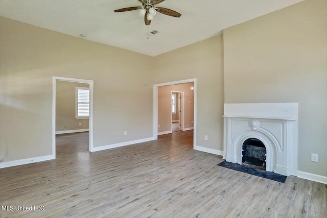 1204 Jackson St, Vicksburg, MS 39183 - unfurnished living room with baseboards, visible vents, ceiling fan, wood finished floors, and a fireplace