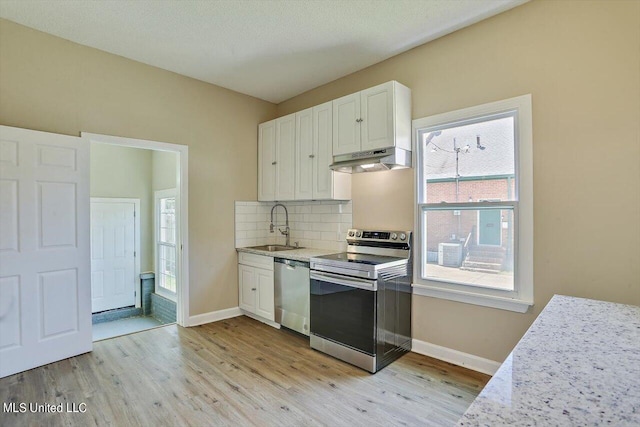 1204 Jackson St, Vicksburg, MS 39183 - kitchen featuring light wood-type flooring, appliances with stainless steel finishes, under cabinet range hood, and a sink