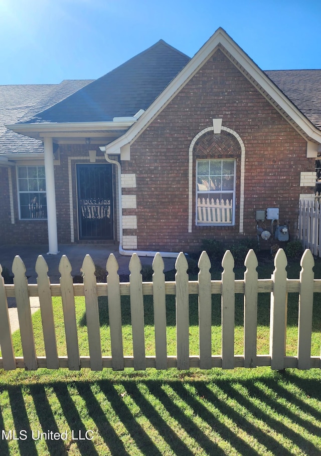 view of side of home with covered porch and a lawn