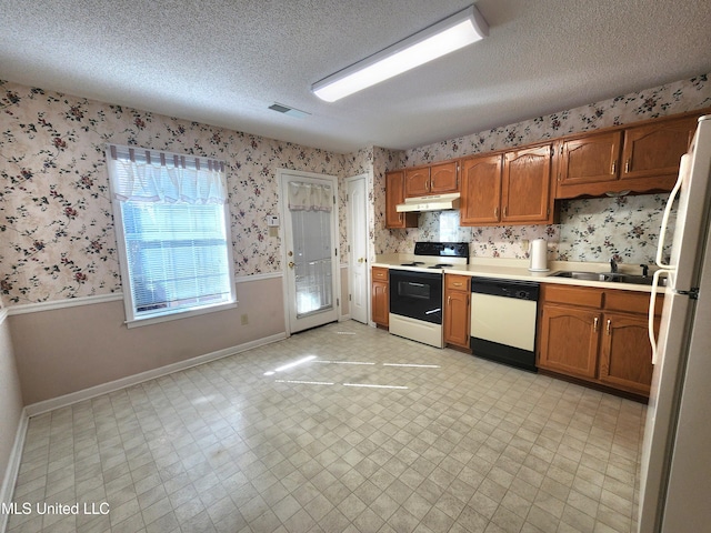 kitchen featuring sink, a textured ceiling, and white appliances