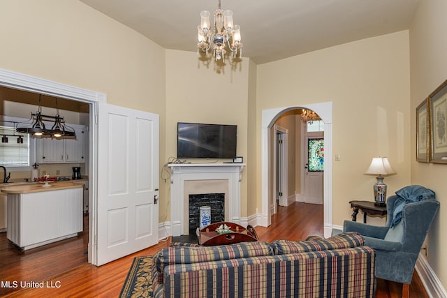729 N Pearl St, Natchez, MS 39120 - living room with wood finished floors, arched walkways, a towering ceiling, a chandelier, and a fireplace