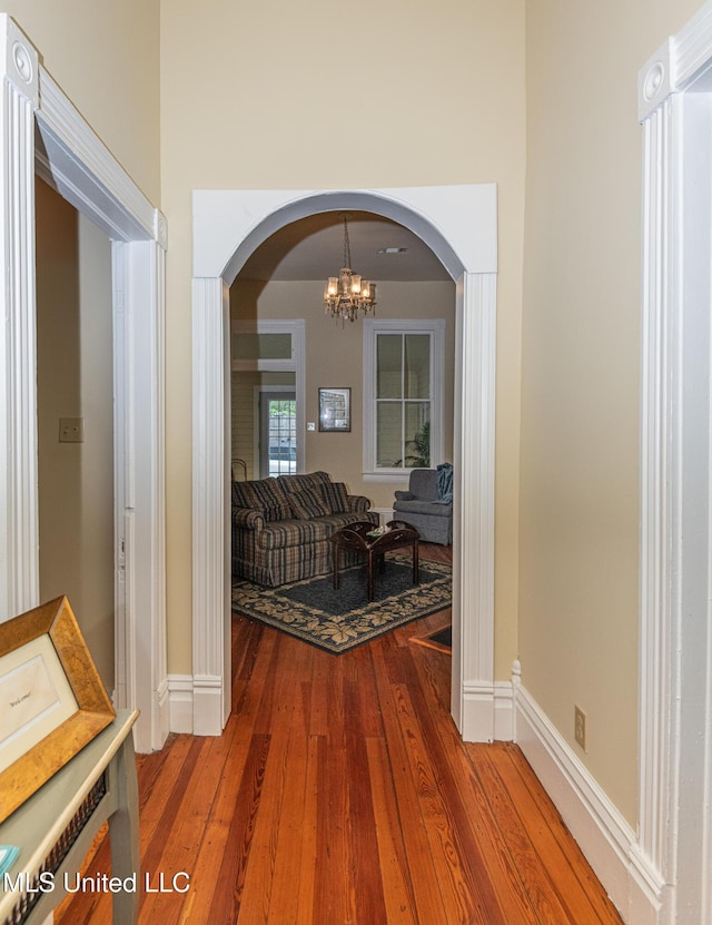 729 N Pearl St, Natchez, MS 39120 - hall featuring hardwood / wood-style floors, arched walkways, a chandelier, and baseboards