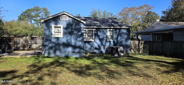 back of property featuring a yard and central AC unit