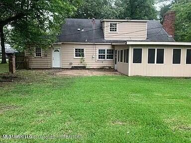 rear view of house with a yard