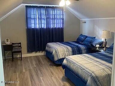 bedroom with hardwood / wood-style floors, ceiling fan, and lofted ceiling