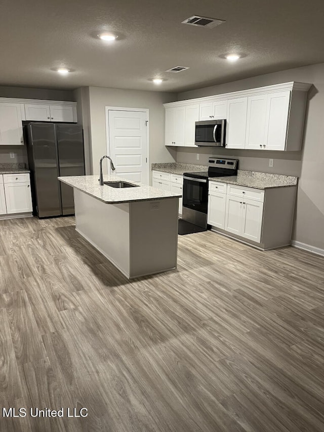 kitchen featuring white cabinetry, appliances with stainless steel finishes, sink, and an island with sink