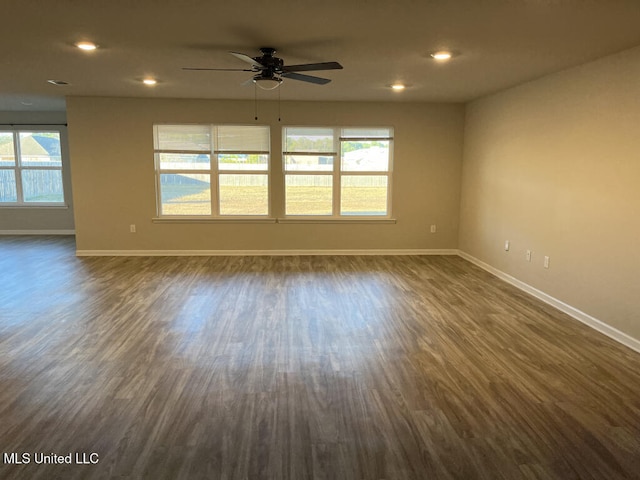 unfurnished room featuring ceiling fan, plenty of natural light, and dark hardwood / wood-style flooring